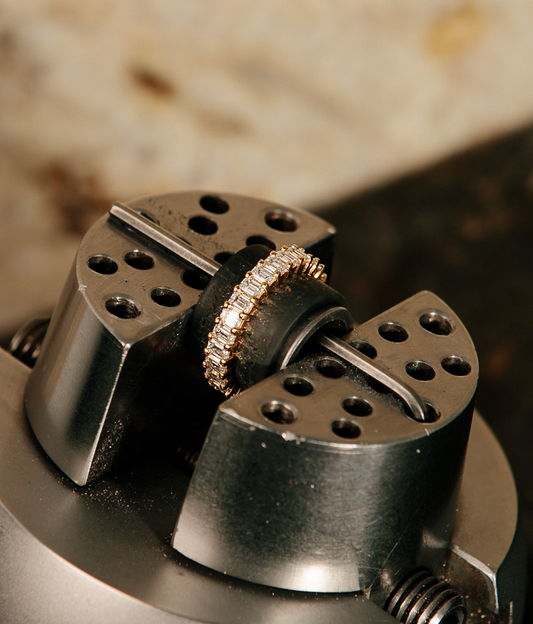 Short emerald-cut diamonds, each precisely set, create a rhythm of light that feels both refined and quietly bold. Their clean geometry catches the eye without excess—an effortless statement of modern luxury. 