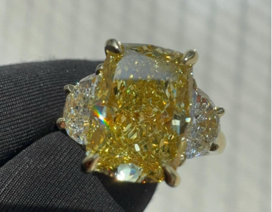 Yellow peridot diamond ring held with black gloves